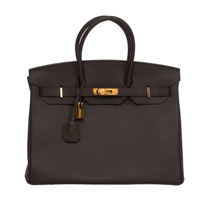 Black handbag with gold hardware on a white background