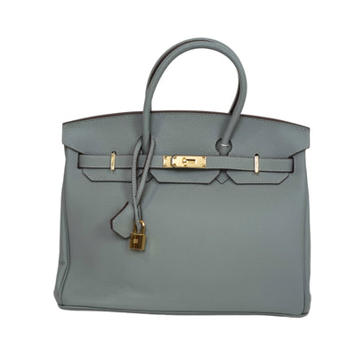 Gray handbag with gold hardware on a white background