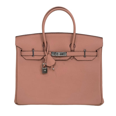 Brown handbag with a silver clasp on a white background