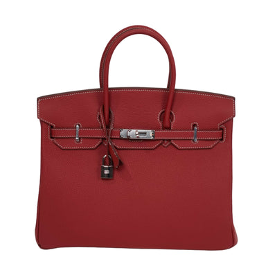 Red handbag with silver hardware on a white background