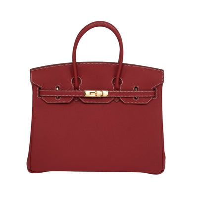 Red handbag with gold hardware on a light gray background