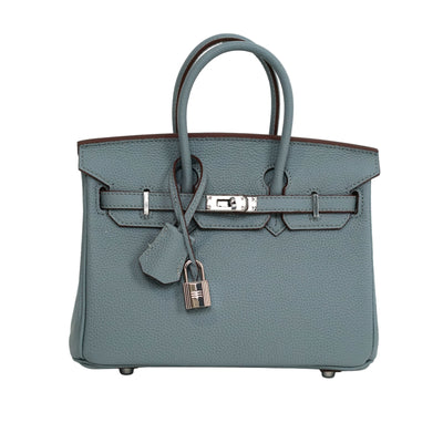 Blue handbag with a silver lock on a white background