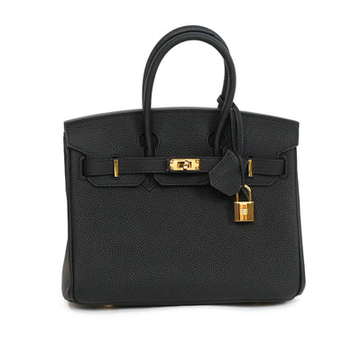 Black handbag with gold hardware on a white background